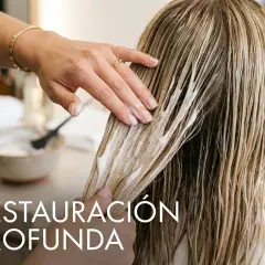 Manos aplicando mascarilla para el cabello, ideal para saber como recuperar el pelo quemado y lograr una restauración profunda.