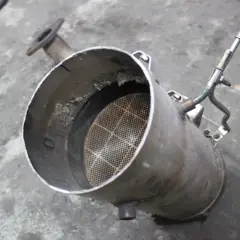 Filtr DPF, czyli co to jest? Widoczny element układu wydechowego z charakterystycznym, siatkowanym wkładem.