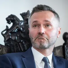 Jarosław Wałęsa, w wieku, w którym doświadczenie miesza się z energią, siedzi na ozdobnym krześle.