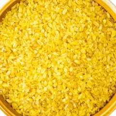 Żółta kasza bulgur w ceramicznej misce. Idealna do przygotowania pysznego posiłku, np. jak ugotować kaszę bulgur w woreczku.