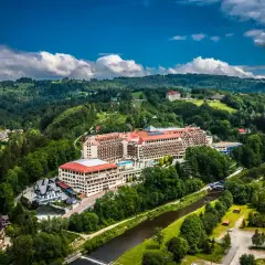 Widok z lotu ptaka na rozległy hotel Gołębiewski w otoczeniu zielonych wzgórz i rzeki. Czy to jedyny hotel Gołębiewski w Polsce?