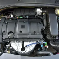 Silnik Citroen C Elysee. Widoczny blok silnika, akumulator, zbiornik płynu hamulcowego i elementy układu dolotowego.