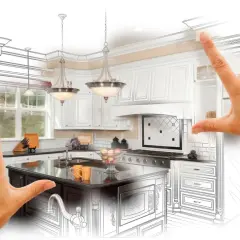 Mains d'un architecte encadrant une cuisine équipée, mêlant esquisse et rendu réaliste. La jurisprudence de la conception de cuisines sur mesure.
