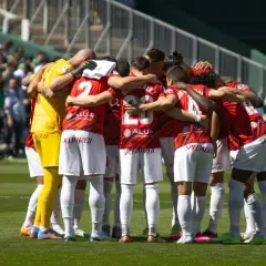 Piłkarze RCD Mallorca w czerwonych strojach tworzą zwarty krąg przed meczem z Valencią CF.