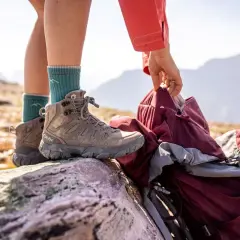 A hiker prepares for adventure, checking their boots. Are boots sized differently than shoes? These sturdy Oboz boots are ready for the trail.