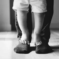 Piedini di bimbo su quelli del papà. Un abbraccio di gambe, un legame forte. Mia figlia preferisce il papà separato, ma i loro piedi uniti raccontano un amore che non si spezza.