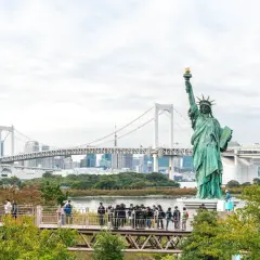 Replika Statuy Wolności w Tokio, gdzie jest statua wolności? W tle most Rainbow Bridge i panorama miasta.
