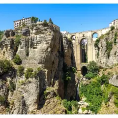 Impresionante Puente Nuevo sobre el Tajo de Ronda, un lugar imprescindible que ver en Ronda. Cascadas y edificios coronan los acantilados.