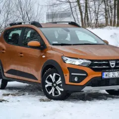 Pomarańczowy Dacia Sandero Stepway na śniegu, gotowy na zimowe wyzwania.