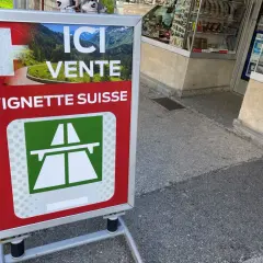 Panneau "Ici vente vignette suisse" avec un paysage alpin. Idéal pour votre séjour de 10 jours en Suisse.