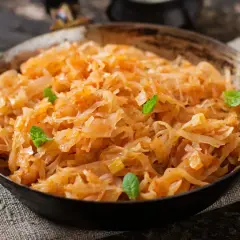 Pyszny bigos wegetariański w misce, ozdobiony listkami mięty. Aromatyczne danie z kapusty i warzyw.
