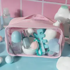 Różowa kosmetyczka z zawartością, w tym szklane perfumy, idealna do bagażu podręcznego Ryanair.