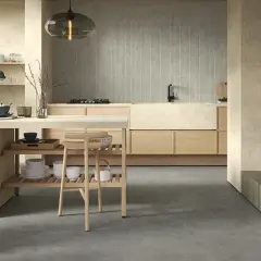 Cucina moderna con finiture in pittura colore sabbia del deserto, isola centrale in legno e camino.