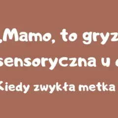 Małe dziecko siedzi na kanapie i bawi się ubraniami.