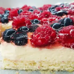 Pyszny biszkopt z galaretką bez kremu, obficie udekorowany malinami i borówkami. Idealny na letnie popołudnie.