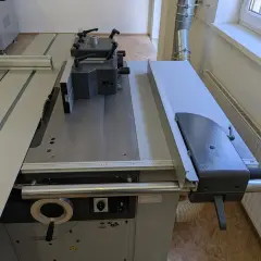 Vue rapprochée d'une scie circulaire FELDER KF700 avec son guide parallèle et son chariot.