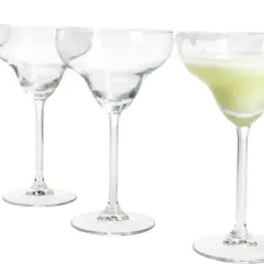 Cztery kieliszki do margarity, jeden z zielonym drinkiem i plasterkiem limonki, pozostałe puste.
