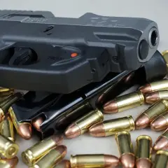Pistolet i magazynki otoczone nabojami. Różne rodzaje pistoletów mogą być prezentowane w podobnych ujęciach.
