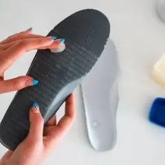 Applying balm to an insole to stop slides from squeaking.
