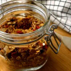 En burk med hemmagjord granola, perfekt som ett bra mellanmål på jobbet. Innehåller nötter, frön och torkad frukt.