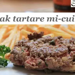 Un steak tartare mi-cuit, savoureux et juteux, servi avec des frites croustillantes et une touche de persil frais. Un délice pour les amateurs de viande.