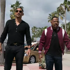 Will Smith i Martin Lawrence w filmach "Bad Boys" idą ulicą w słoneczny dzień, otoczeni palmami.