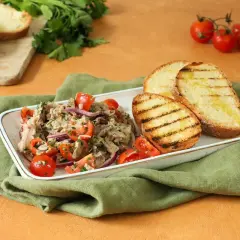 Deliziosa insalata di bollito con pomodorini, cipolla rossa e pane abbrustolito, un piatto fresco e saporito.
