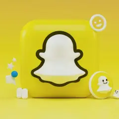 Ikona Snapchata z małymi duchami i emotikonami na żółtym tle.