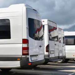 Rząd białych busów gotowych do wyjazdu z Zakopanego na Palenicę Białczańską.