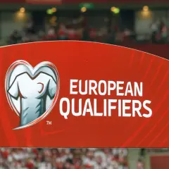 Czerwony baner z napisem "EUROPEAN QUALIFIERS" i symbolem koszulki w sercu. To część rozgrywek eliminacyjnych do Mistrzostw Europy.
