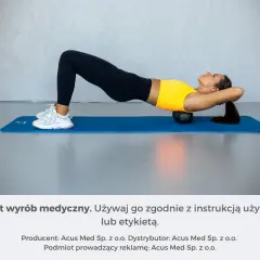Kobieta wykonuje ćwiczenia na wdowi garb, leżąc na macie z wałkiem pod plecami.