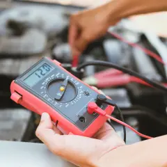 Diagnostic d'une électrovanne turbo défectueuse symptôme : un mécanicien utilise un multimètre pour tester le circuit.
