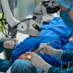 Chirurg wykonuje przeszczep rogowki, używając mikroskopu operacyjnego. Pacjent leży pod znieczuleniem.