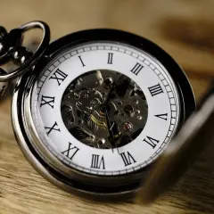 Elegancki zegarek kieszonkowy z widocznym mechanizmem. Czasomierz wskazuje godzinę, która minęła półtorej godziny od ostatniego nakręcenia.