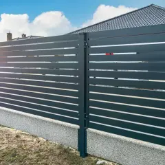 Nowoczesne, ciemnoszare ogrodzenie z poziomych desek na betonowej podmurówce.