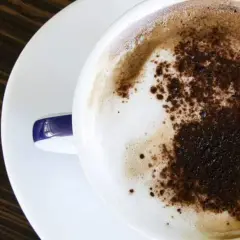 Un delizioso cappuccino a casa, con schiuma soffice e cacao spolverato. Un momento di puro piacere.