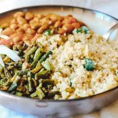 Gesundes Gericht mit Quinoa, Bohnen, grünem Gemüse und Kohlstreifen in einer Schüssel.