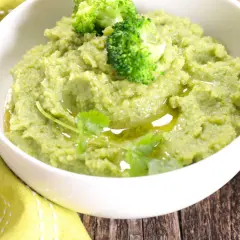 Un bol de purée de brocolis onctueuse, garnie de fleurettes de brocolis et d'un filet d'huile d'olive. Une touche de verdure pour un plat sain.