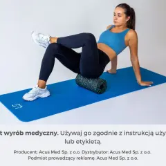Kobieta wykonuje ćwiczenia na mięsień gruszkowaty, używając rollera na macie.