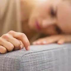 Smutna kobieta opiera głowę na dłoni, czując pustkę. Czy to anhedonia co to?