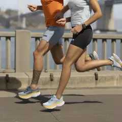 Dwie osoby biegną po moście w butach Hoka, gotowe na wyzwanie kingrunner ultra.