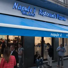 Davanti al ristorante pizzeria "Napule è" a Milano, gente fuori e dentro.