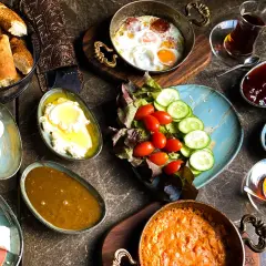 Pyszne śniadanie w jednej z najlepszych restauracji Warszawa: jajka sadzone, sery, pieczywo, oliwki, dżem i herbata.