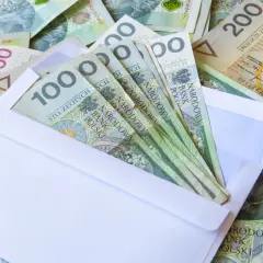 Koperta z banknotami 100 zł, część większej kwoty, jak darowizna od rodziców 50 tys. zł.