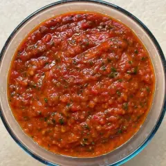Bagnetto rosso piemontese in una ciotola di vetro, un condimento saporito e piccante, perfetto per accompagnare bolliti e carni.