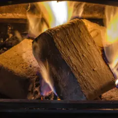 Zwei Holzbriketts brennen im Kamin. Die lange Brenndauer sorgt für wohlige Wärme.