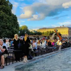 Folk njuter av sommarkvällen vid fontänen, en del av programmet för kulturfestivalen.