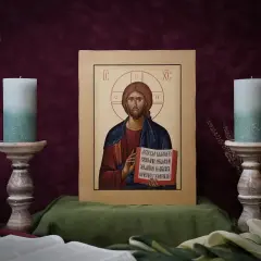 Ikona Chrystusa Pantokratora, otoczona świecami i kwiatami, emanuje spokojem.