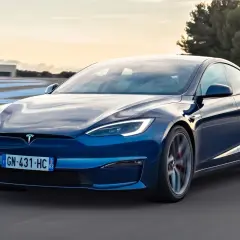 Niebieska Tesla Model S pędzi po torze wyścigowym. Zastanawiasz się, ile kosztuje Tesla Model S?