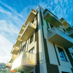 Immeuble moderne aux balcons saillants, sous un ciel bleu zébré de nuages. Un projet qui pourrait faire l'objet d'un recours pour perte d'ensoleillement.